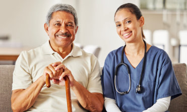 nurse and elderly man looking at the camera