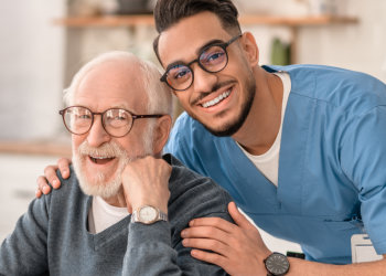 nurse and elderly man looking at the camera