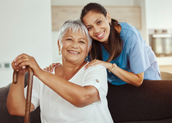 nurse and elderly man smiling and looking at the camera