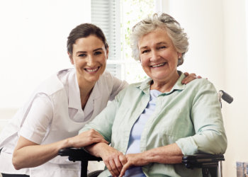 nurse and elderly woman looking at the camera