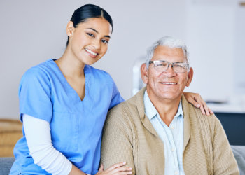 nurse and elderly man looking at the camera