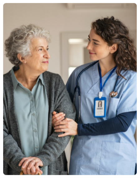 A nurse and an older woman are holding hands.