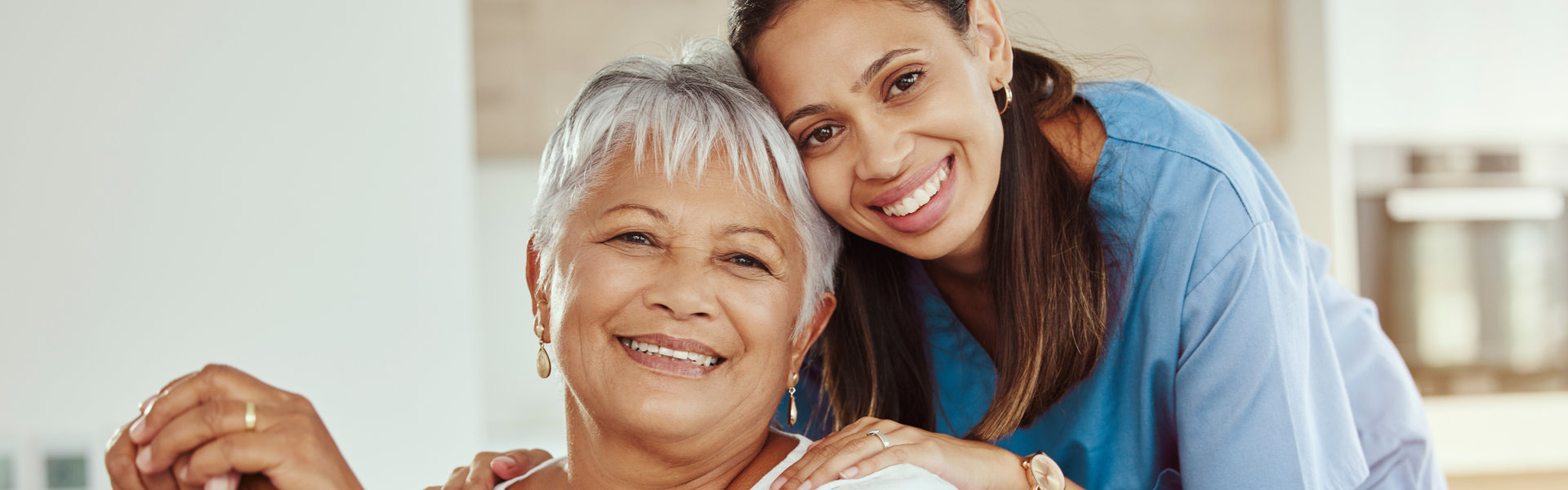 nurse and elderly man smiling and looking at the camera