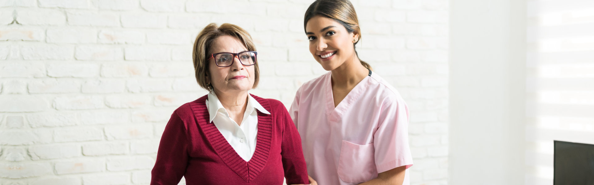 nurse and elderly woman looking at the camera