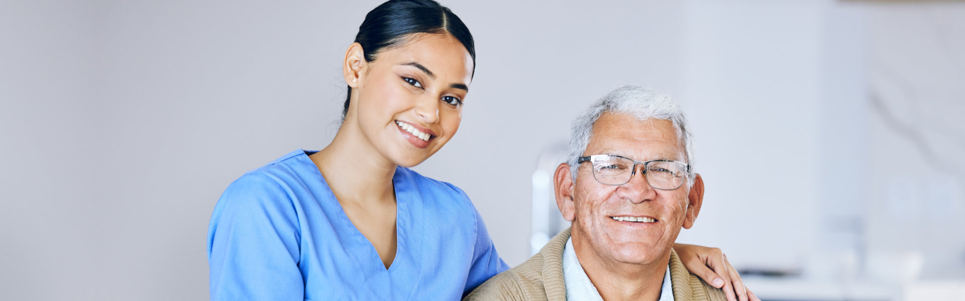 nurse and elderly man looking at the camera