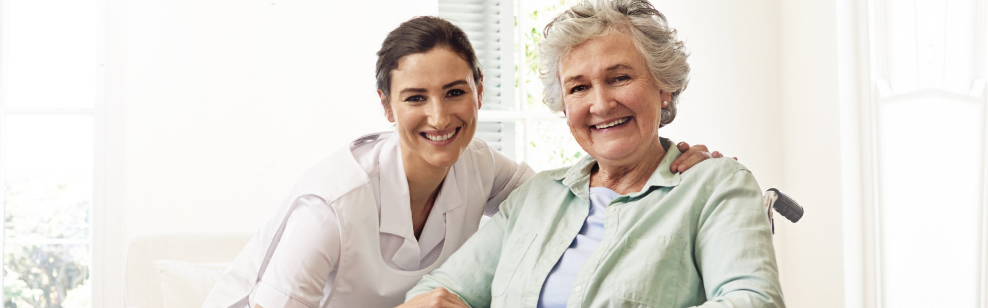 nurse and elderly woman looking at the camera