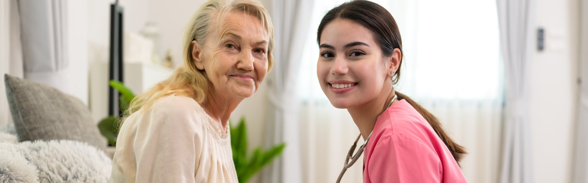 nurse and elderly woman looking at the camera