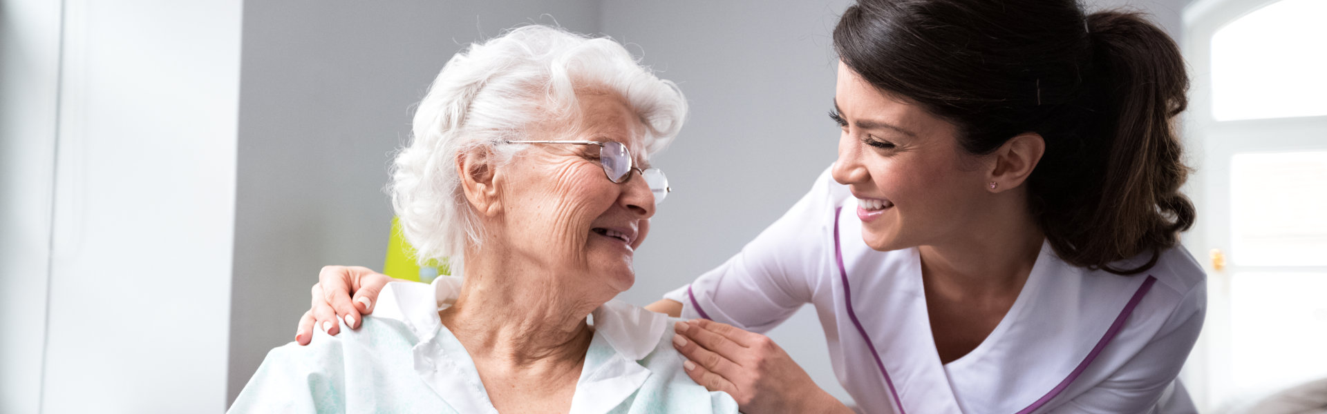 nurse and elderly woman looking at each other